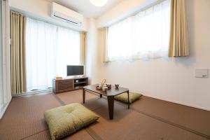 a living room with a table and a tv at GN98 Saiwaicho Osaka in Osaka