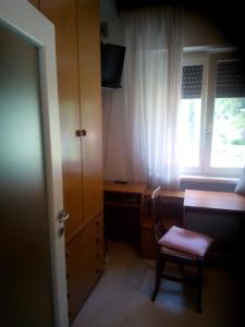 a room with a desk and a chair and a window at PIETRAMURATA APPARTAMENTO VISTA MONTAGNA terzo piano in Dro