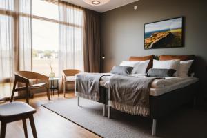 ein Schlafzimmer mit einem großen Bett, einem Tisch und Stühlen in der Unterkunft Barsebäck Resort Hotell in Löddeköpinge