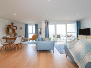 a living room with a couch and a table and chairs at Fistral Retreat in Newquay