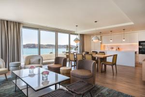 a living room with a table and chairs and a kitchen at Hyatt Regency Lisbon in Lisbon