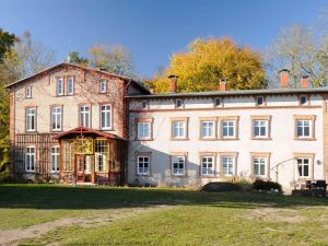 a large brick house with a large yard at Spacious Apartment in Lalendorf with Barbecue in Krassow