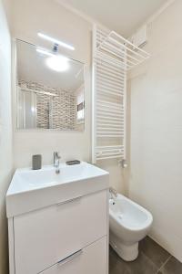 uma casa de banho branca com um lavatório e um WC em Ca' 84 Burano em Burano