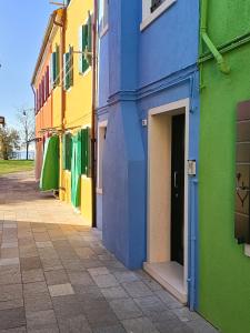 a colorful building with a door open on a street at Ca' 84 Burano in Burano