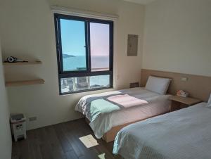 1 dormitorio con 2 camas y ventana grande en Ran Ran 29 Guest House en Beigan