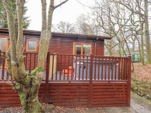 una piccola cabina di legno con una staccionata di legno di 25 Thirlmere a Windermere