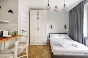 niewielka sypialnia z łóżkiem i biurkiem w obiekcie KING APART Dickensa w Warszawie