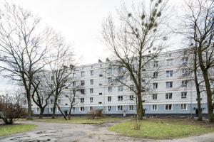 um edifício branco com árvores em frente em KING APART Dickensa em Varsóvia