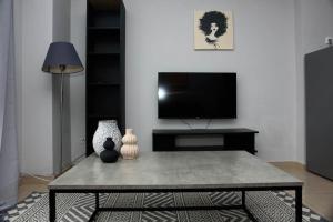 un soggiorno con tavolino e TV di Stelina’s Cosy Loft - Ideal Spot a Salonicco