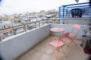 2 sedie rosa e un tavolo sul balcone di Stelina’s Cosy Loft - Ideal Spot a Salonicco