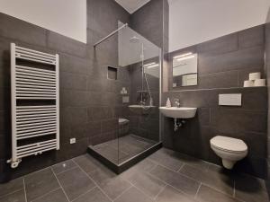 a bathroom with a shower and a toilet and a sink at RAJ Living - 300m2 Loft with 7 Rooms - 15 Min Messe DUS & Old Town DUS in Düsseldorf