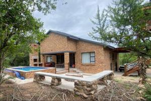 a brick house with a swimming pool in front of it at Sonador Bush House, 4bedr, 3bathr in Marloth Park in Marloth Park