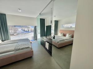 a bedroom with two beds and a large window at Kaps Wohnen in Saalfelden am Steinernen Meer