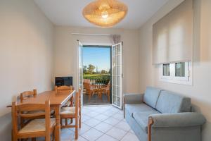 a living room with a table and a couch and a dining room at Captain's Villas in Katelios