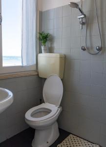 La salle de bains est pourvue de toilettes, d'un lavabo et d'une douche. dans l'établissement Hotel Atlas, à Cesenatico