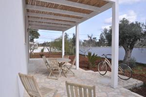 eine Terrasse mit einem Tisch, Stühlen und einem Fahrrad in der Unterkunft Villa Rachele in Sant'Isidoro