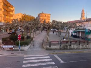 una calle de la ciudad con una señal de stop y árboles en Albergue O Santo, en Arzúa