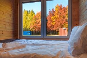 Cama en habitación con 2 ventanas en Arche Siedlisko Celiny, en Celiny