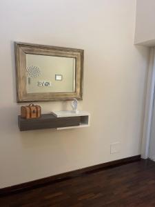 un miroir sur un mur blanc avec une étagère et un miroir dans l'établissement MATTIA'S HOME, à Caserte