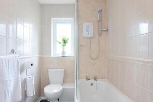 een badkamer met een douche, een toilet en een wastafel bij Elegance Graceland in Gillingham