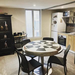 a kitchen with a table and chairs and a refrigerator at Les Jedis Saint Jean de Losne, La Diligence in Saint-Jean-de-Losne