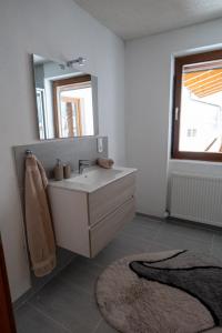 y baño con lavabo, espejo y alfombra. en Haus Kappeller en Bach