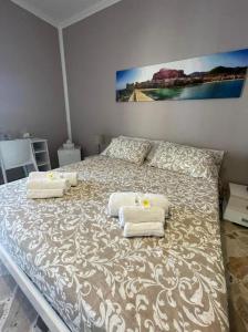 a bedroom with a large bed with towels on it at B&B DEA in Cefalù
