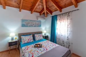 a bedroom with a bed and a wooden ceiling at Posidonia Luxury Villas Kolympia in Kolimbia