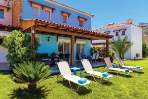 a group of chairs in the yard of a house at Posidonia Luxury Villas Kolympia in Kolimbia