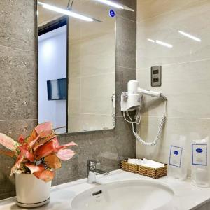 a bathroom with a sink and a mirror at La Vita Hotel in Vung Tau