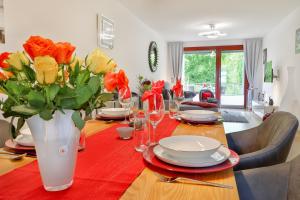 een eettafel met een vaas met bloemen erop bij Major mit Ostseeblick Haus Fore in Lohme