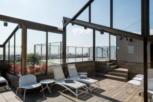 a balcony with chairs and tables on a building with windows at Catalonia Park Putxet in Barcelona