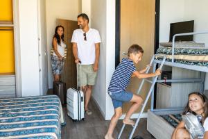 eine Gruppe von Personen steht in einem Zimmer mit Etagenbetten in der Unterkunft Bikini Tropicana Family Hotel in Lido di Savio