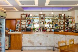 a bar in a restaurant with a lot of bottles at Ilyssion Holidays Hotel in Ialyssos