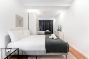 GuestReady - Uptown suites 5 في بورتو: غرفة نوم بسرير ابيض كبير ونافذة
