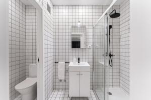 GuestReady - Uptown suites 5 في بورتو: حمام من البلاط الأبيض مع مرحاض ومغسلة