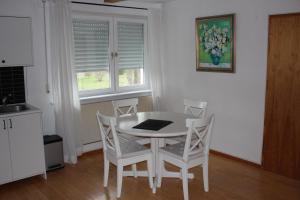 - une table et des chaises blanches dans une cuisine avec une fenêtre dans l'établissement Ferienwohnung Nett, à Blankenheim