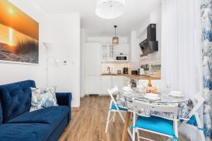 a living room with a blue couch and a table at Apartament Holiday 8/25 in Rewal