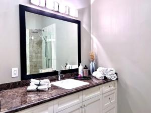 a bathroom with a sink and a large mirror at Kia Oceanview Property in West Vancouver