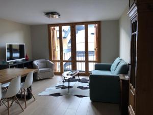 uma sala de estar com um sofá azul e uma mesa em Apartamento Casa Francho 2 em Panticosa