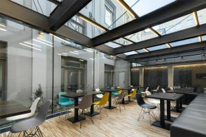 una sala da pranzo con tavoli, sedie e finestre di MOODs boutique hotel a Praga