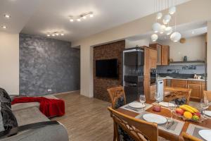 a kitchen and a dining room with a table and chairs at Lovely 2-bdrm condo ideal for couples and family with children, free parking on premises in Riga