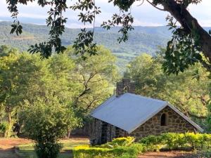 an old stone building with a white roof at Hazyview Accommodation, Bon Repose Cottages 3&4 in Hazyview