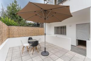 une terrasse avec une table, des chaises et un parasol dans l'établissement GuestReady - Amazing stay near Cedofeita Church, à Porto