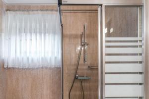 una ducha con una puerta de cristal junto a una cortina en Angeiras Beach House - C3 en Lavra