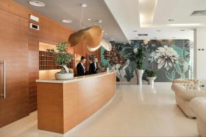 een lobby van een hotel met mensen die bij een receptiebalie staan bij Hotel Parigi in Bibione +24 foto's