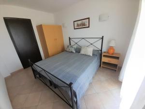 Nuova Valmar "Bilo 52" vista mare في كوستا ري: غرفة نوم مع سرير وإطار سرير أسود وموقف ليلي
