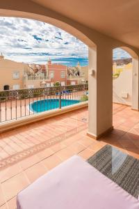 a balcony with a view of a swimming pool at luxury duplex apartment with beautiful sea views in Palm-mar