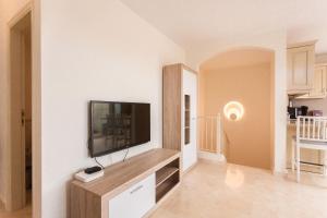 a living room with a flat screen tv on a wall at luxury duplex apartment with beautiful sea views in Palm-mar
