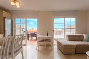a living room with a couch and a table at luxury duplex apartment with beautiful sea views in Palm-mar